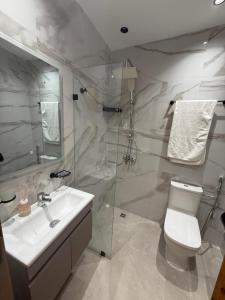 a bathroom with a sink and a toilet and a shower at اقامة هبة 4 in Yebha