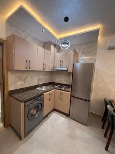 a kitchen with a washer and a sink and a refrigerator at اقامة هبة 4 in Yebha