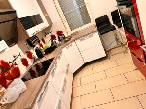 a kitchen with white cabinets and tomatoes on the counter at Zimmer heilbronn in Heilbronn