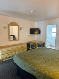 a hotel room with a bed and a mirror at Motel Garberville in Garberville