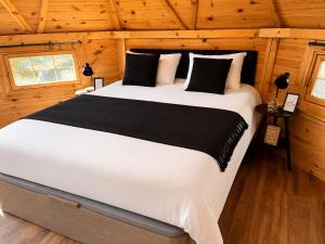 a bedroom with a large bed in a wooden room at Kota Évasion & Spa in Cahors