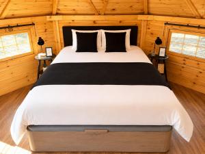 a bedroom with a large bed in a wooden room at Kota Évasion & Spa in Cahors