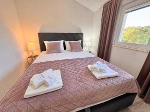 a bedroom with a bed with towels on it at Apartments Fortuna in Biograd na Moru