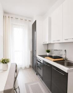 a kitchen with black and white cabinets and a sink at Liam House - Stanza 2 in Limbiate