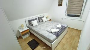a small white bedroom with a bed and a window at Apartman Đurić in Donji Milanovac +15 photos