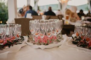 a group of wine glasses on a table with flowers at Black Pearl Tisno in Tisno
