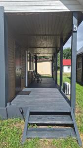 a covered porch with benches on the grass at Amber coast - domek nr 5 in Jantar