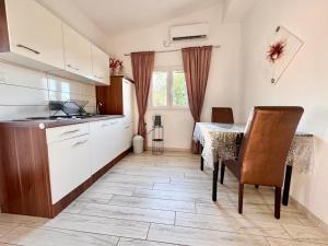 a kitchen and dining room with a table and chairs at Apartments Fortuna in Biograd na Moru