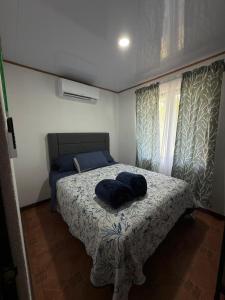 a bedroom with a bed with a blue pillow on it at Mi rinconcito en Liberia in Liberia