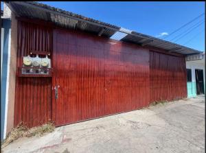 a red metal garage door with two meters on it at Mi rinconcito en Liberia in Liberia
