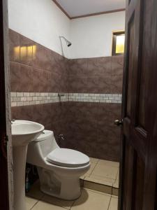 a bathroom with a toilet and a sink at Mi rinconcito en Liberia in Liberia