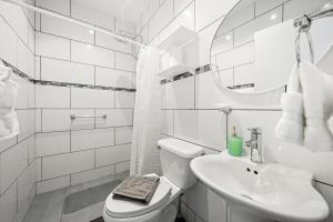 a white bathroom with a toilet and a sink at Villa Sirena Azul Apt 2 in Palm-Eagle Beach +12 photos