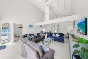 a living room with two couches and a table at Villa Sirena Azul Apt 2 in Palm-Eagle Beach