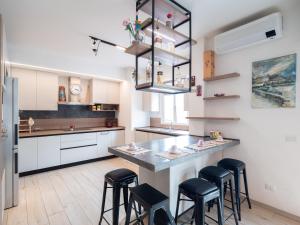 a kitchen with a large counter with stools in it at Bellanotte suite and dreams in Bellano