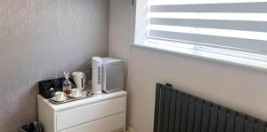 a room with a television on a dresser with a window at The Dorking Hideaway B&B in Dorking