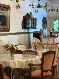 a dining room with tables and chairs with flowers on them at Kanu Club - ośrodek wypoczynkowy in Nowy Zyzdrój