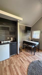 a kitchen and dining room with a table in it at Domki na Wesołej 2 in Połczyno +8 photos
