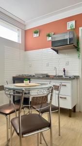 a kitchen with a table and chairs in a room at Espaço Primavera in Pouso Alegre