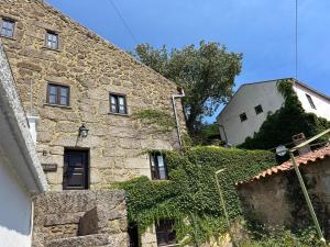 an old stone building with ivy growing on it at Casas Serranas in Gouveia