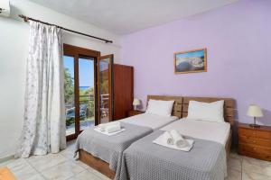 a bedroom with two beds and a window at Athina Villa in Koinyra