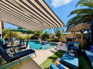 a patio with a pool with chairs and a table at Amazing Grace Vacation Home in Las Vegas