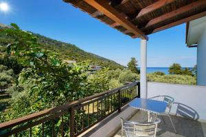 a balcony with a table and chairs and the ocean at Athina Villa in Koinyra