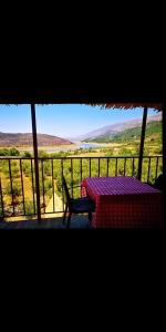 a table and chair on a balcony with a view at Saghbine bungalows in ‘Ayn Zubdah