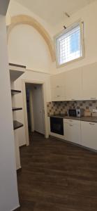 a kitchen with white cabinets and a window at G & N Luxury House in Lecce