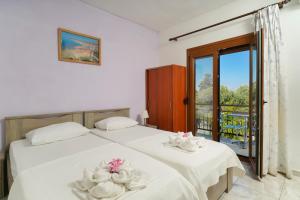 a bedroom with two beds with white sheets at Athina Villa in Koinyra