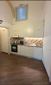 a large kitchen with white cabinets and a window at G & N Luxury House in Lecce