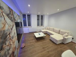 a living room with a couch and a table at Home cinema in Liège