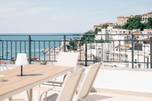 a balcony with tables and chairs and a view of the ocean at Laz Palace in Ulcinj