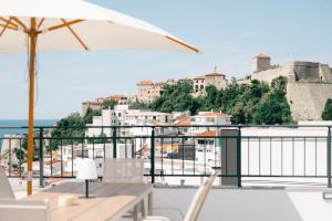 a view of a city from a balcony with an umbrella at Laz Palace in Ulcinj