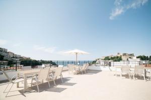 a patio with tables and chairs and an umbrella at Laz Palace in Ulcinj