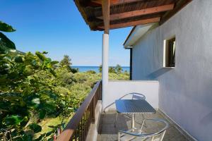 a blue table and chairs on a balcony with the ocean at Athina Villa in Koinyra