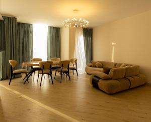 a living room with a couch and a table and chairs at Mos House in Kobuleti