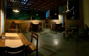a restaurant with tables and chairs and a brick wall at Kumaru Pousada e Restaurante in Palmeiras