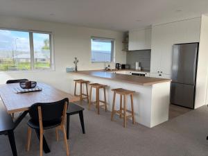 a kitchen with a table and chairs and a refrigerator at Carters Beach Escape in Carters Beach