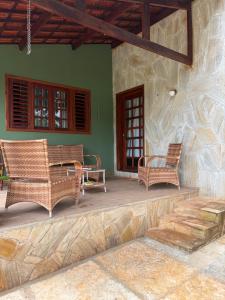 a porch of a house with chairs and a table at Recanto da Julie in Mulungu