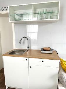 a kitchen with white cabinets and a sink at Modernes Studio mit Küche, WLAN, Parkplatz in Dingolfing +8 photos