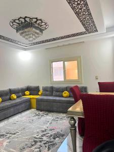 a living room with a couch and a table at Vrtn home in Al Ghuşnah