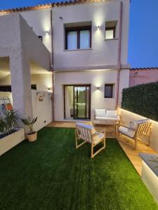 a backyard with a green lawn and a house at Karasole in San Teodoro