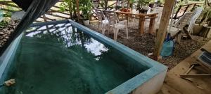 a pool of water with chairs and a table at Red's Cafè & Resto- Glass Cabin in Manolo Fortich