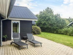 two chairs sitting on a patio next to a house at 5 star holiday home in Højslev in Højslev +36 photos