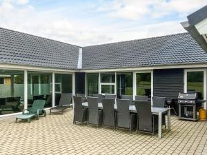 a patio with a table and chairs and a grill at 5 star holiday home in Højslev in Højslev