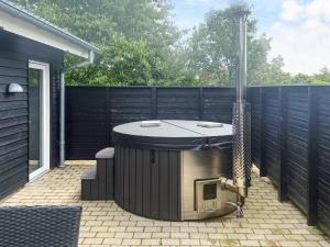 a hot tub on a patio next to a fence at 5 star holiday home in Højslev in Højslev