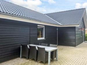 a patio with a table and chairs and a building at 5 star holiday home in Højslev in Højslev