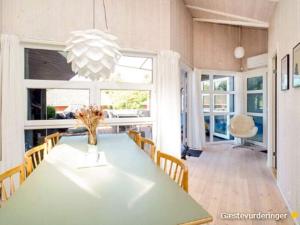 a dining room with a green table and chairs at 7 person holiday home in Græsted-By Traum in Græsted
