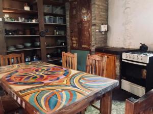 a kitchen with a table with a colorful table cloth on it at Espacio Circular Eco Hostel in San Marcos Sierras