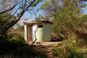 a small white building in the middle of a forest at Espacio Circular Eco Hostel in San Marcos Sierras